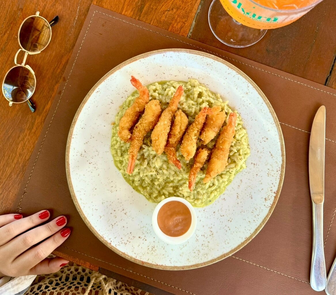 Camarões empanados sobre risoto verde