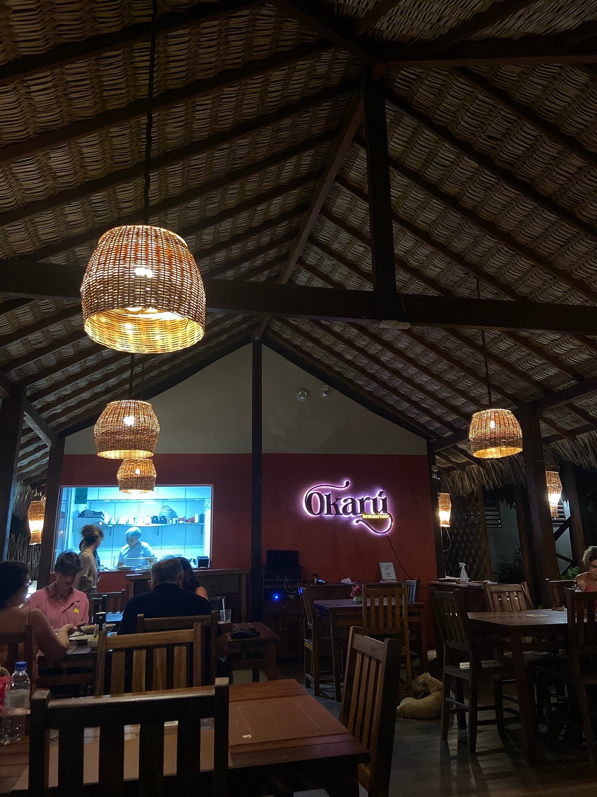 Salão do Okarú à noite, com luminárias de palha
