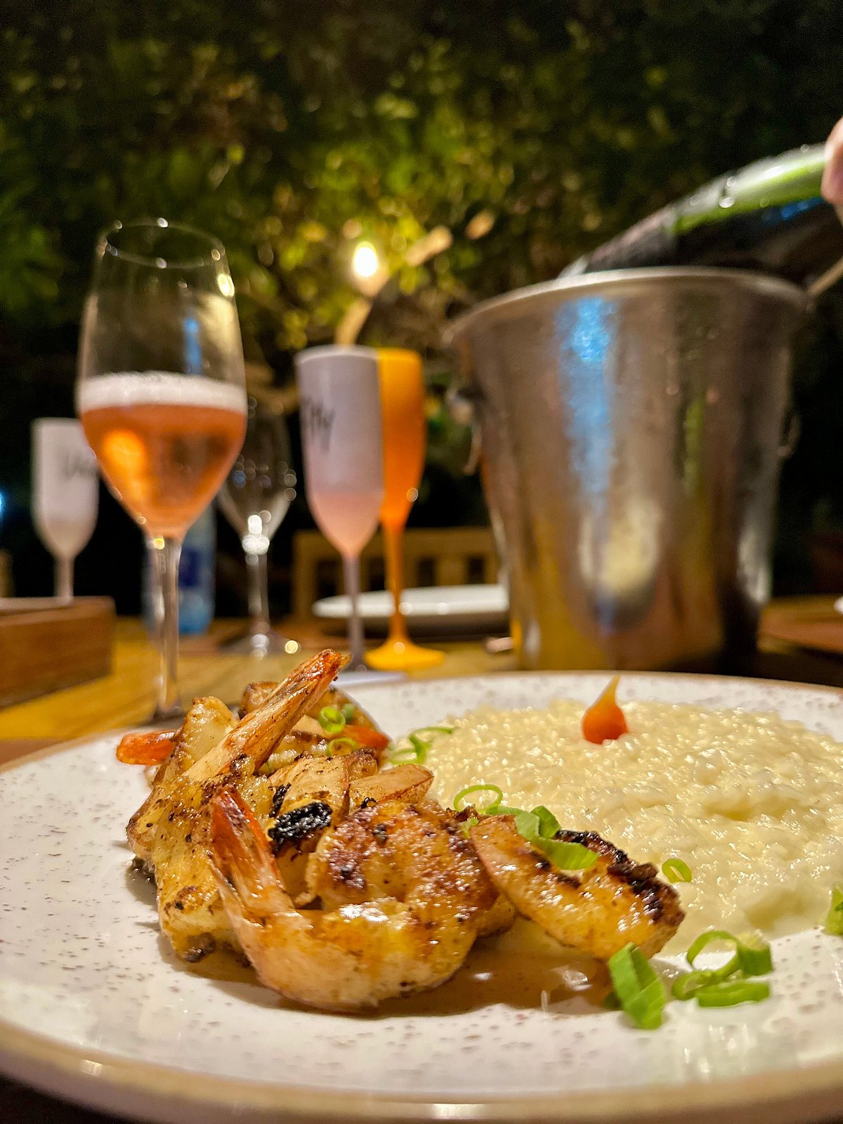 Camarões grelhados com risoto e vinho rosé à noite