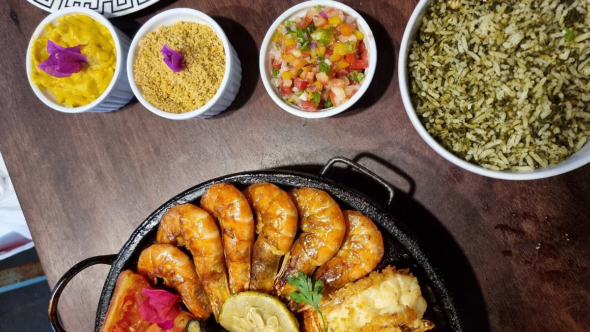 Mesa com pratos regionais: camarões, farofa, vinagrete e arroz